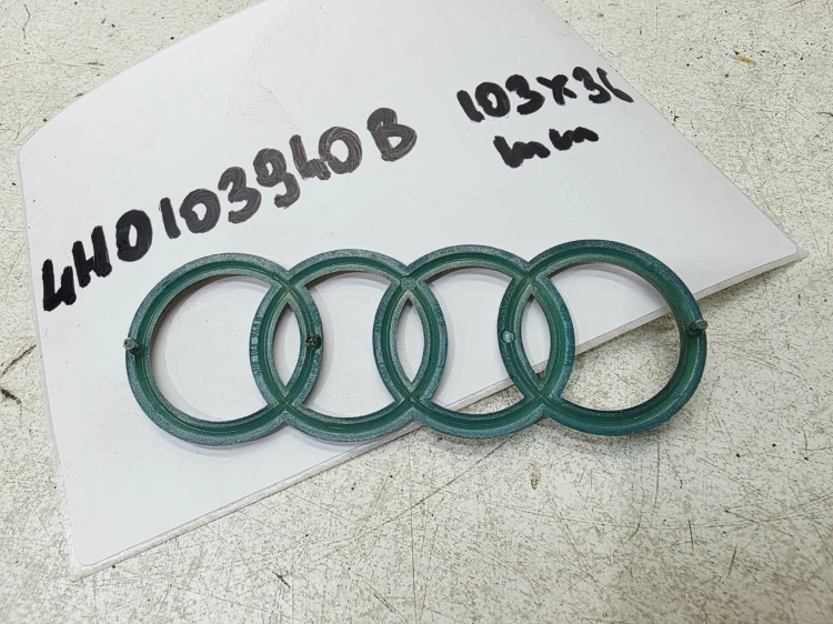 ZNACZEK EMBLEMAT Z POKRYWY SILNIA AUDI A3 A4 A5 A6 4H0103940B 103MMX36MM